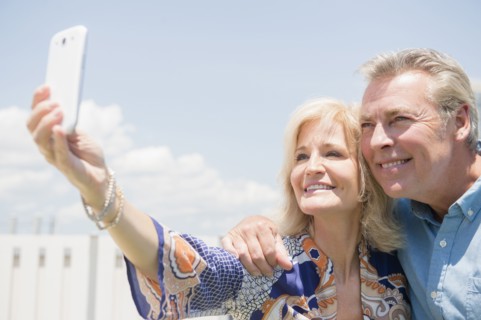 Portrait of couple posing for smartphone selfie