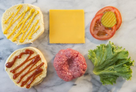 Close-up shot of hamburger ingredients in rows on table