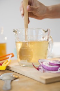 Studio shot of woman's hand stirring liquid in jug