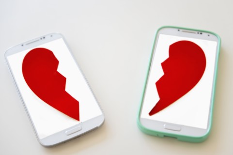 Studio shot of smart phones with broken heart on screen
