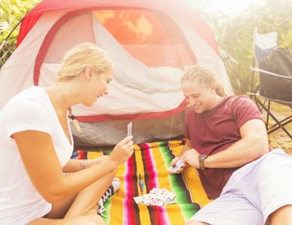 Couple playing cards in front of tent