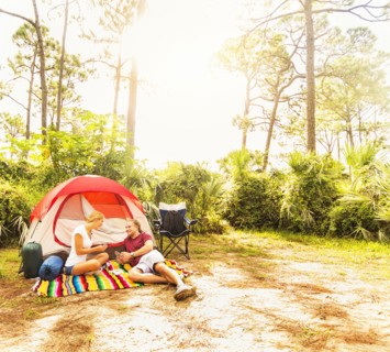 Couple playing cards in front of tent