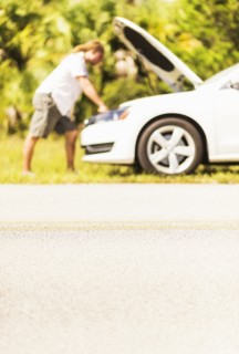 Young man looking at car engine