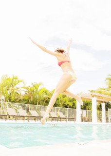 Woman jumping into swimming pool