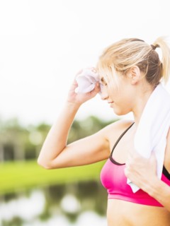 Woman whipping sweat off forehead