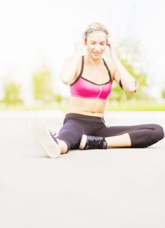Young woman listening to music while stretching