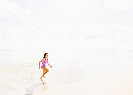 Girl (6-7) running on beach