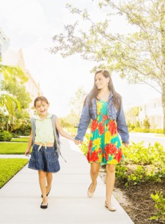 Girl (6-7) walking to school with her mom