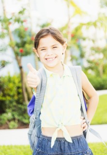 Portrait of girl (6-7) with thumbs up