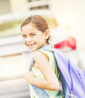 Portrait of smiling student (6-7) outdoors