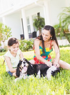 Girl (6-7) with mom and dog in backyard