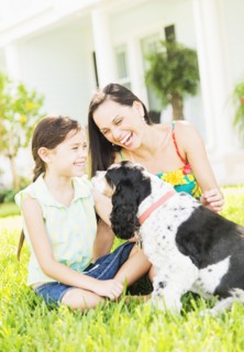 Girl (6-7) with mom and dog in backyard