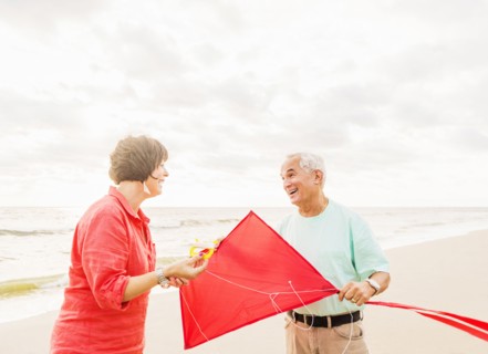 Couple flying kite together on beach