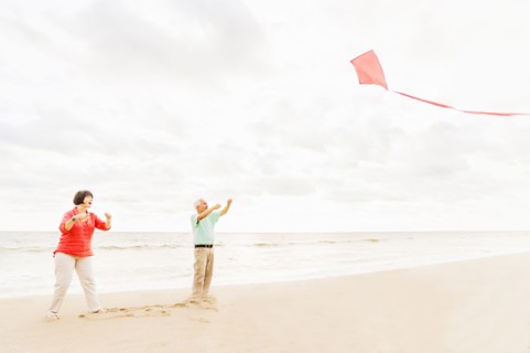 Couple flying kite together on beach