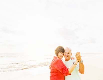 Couple dancing on beach at sunrise