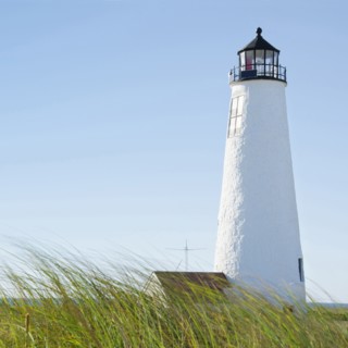 Great Point Lighthouse against clear sky with marram grass in foreground
