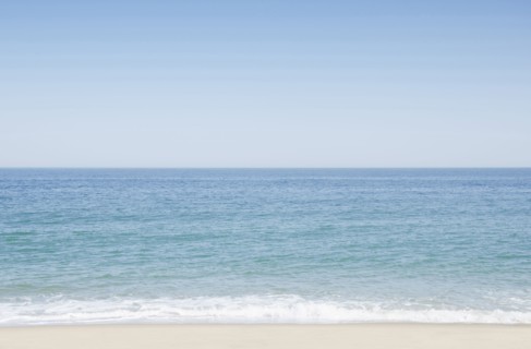 Seascape with surf on sandy beach