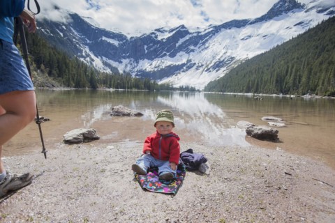 Boy (4-5) sitting on lakeshore