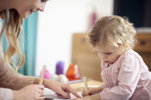 Woman teaching young girl at home