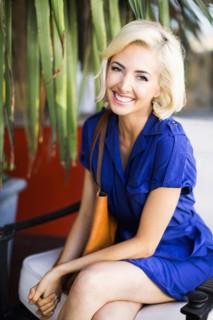 Woman with dyed hair sitting and smiling to camera