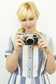 Studio shot of woman holding camera