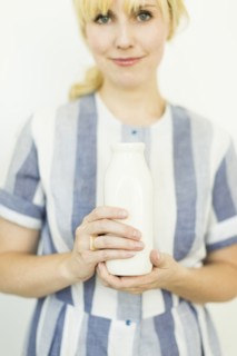 Studio shot of woman holding milk bottle