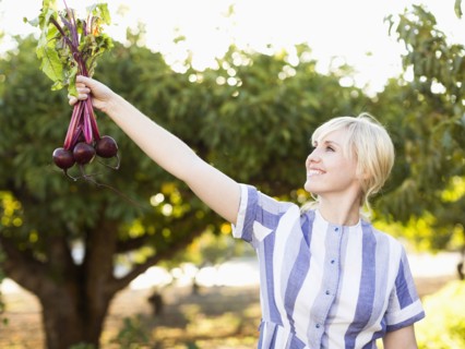Woman wearing striped dress working in vegetable garden