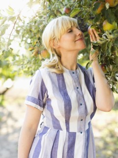 Woman picking apples in orchard