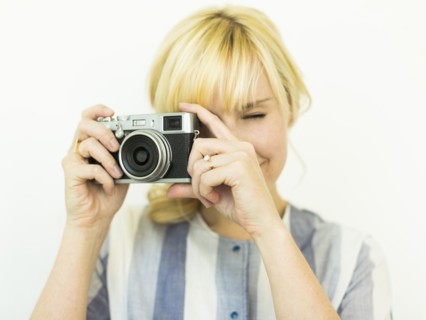 Studio shot of woman holding camera