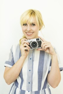 Studio shot of woman holding camera