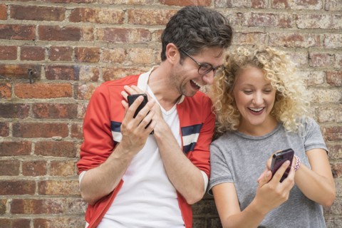 Couple sharing messages on cell phones.