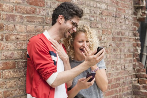 Couple sharing messages on cell phones.