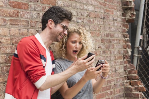 Couple sharing messages on cell phones.