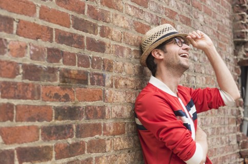 Portrait of mid adult man in front of brick wall.