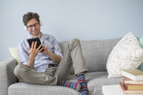 Man sitting on sofa listening to music.