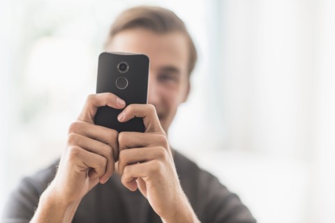 Close-up of man using mobile phone.