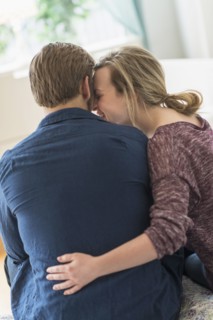 Rear view of young couple hugging.