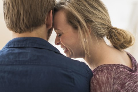 Close-up of smiling woman leaning on man.