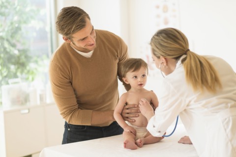 Small boy (2-3) with his father and female doctor in doctor's office.