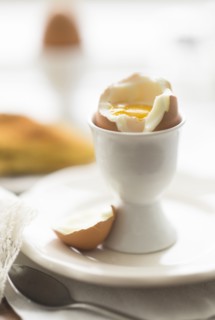 Close up of soft boiled egg in egg cup.