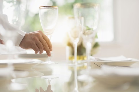Close up of man's hand setting place in restaurant.
