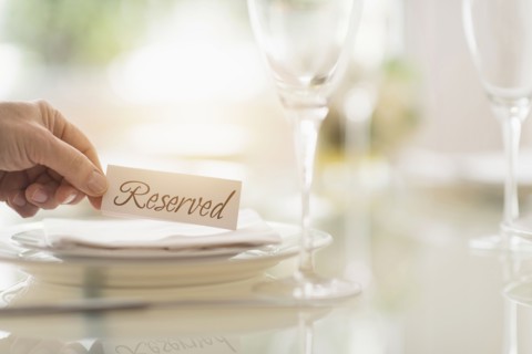 Close up of man's hand setting place in restaurant.