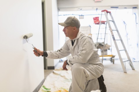 Manual worker painting wall.