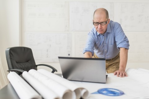 Mature architect using laptop in office.