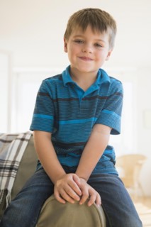 Portrait of boy (6-7) sitting on sofa