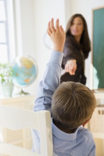 Female teacher and schoolboy (6-7) in classroom