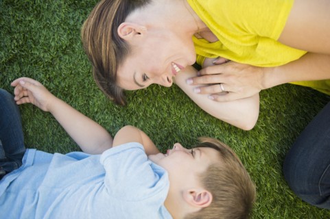 Mother and son (6-7) relaxing on grass