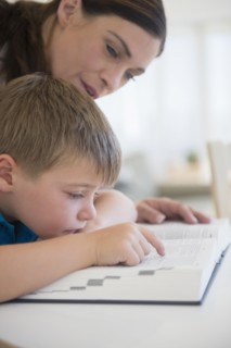Female teacher and schoolboy (6-7) in classroom