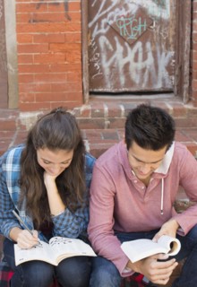 Young couple reading book and doing crossword