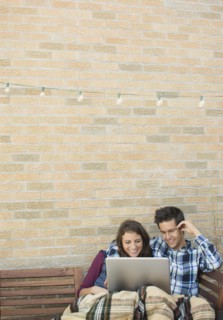 Young couple using laptop on roof